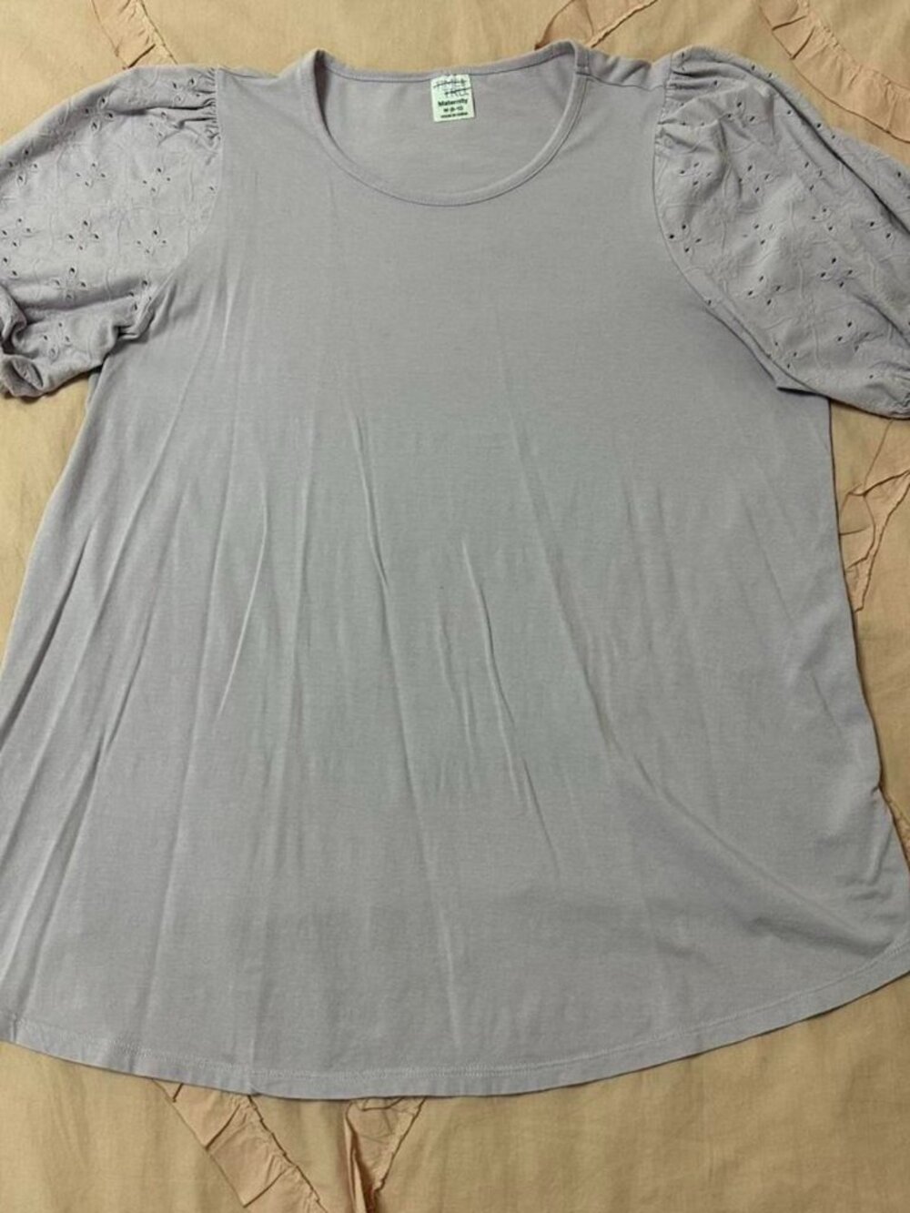 Lilac maternity top with embroidered eyelet puff sleeves.